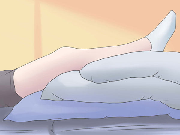 Kê chân lên gối mềm khi nằm cũng là giải pháp cho các bà bầu bị chuột rút. (Ảnh minh họa)